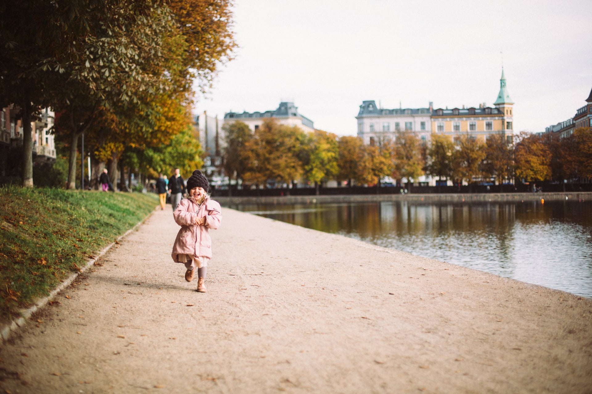 Young girl smiling on path by water