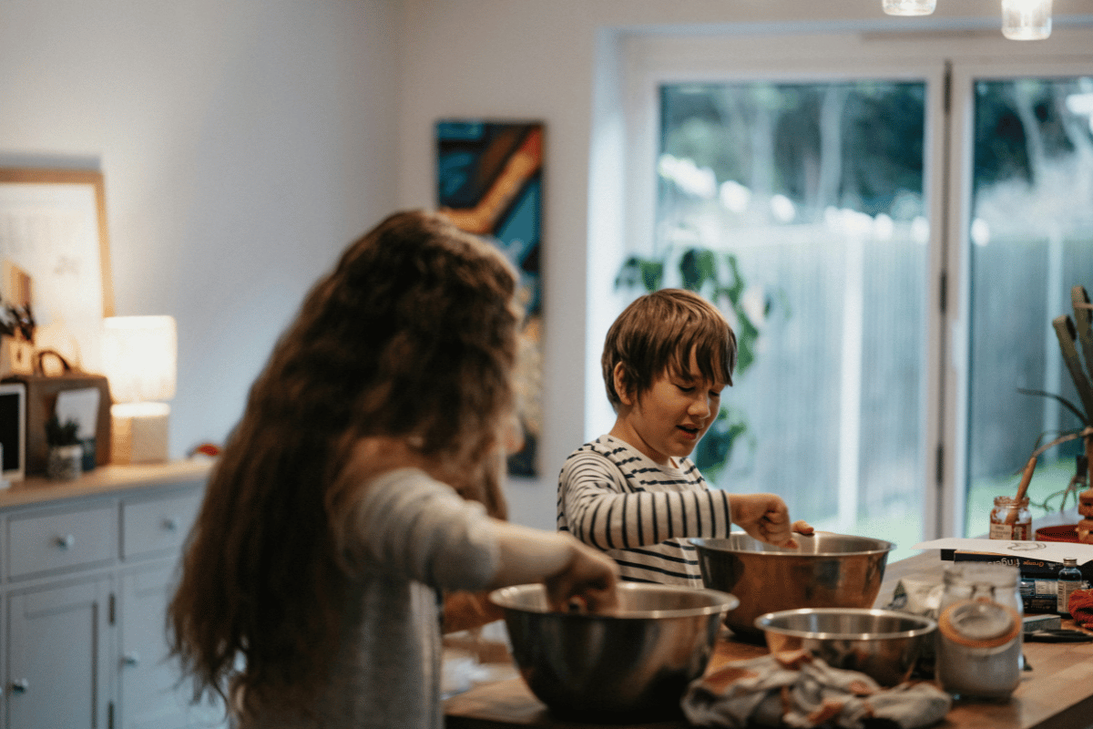 Family cooking together in kitchen preparing food during family bonding activity