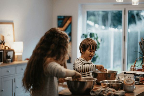Family cooking together in kitchen preparing food during family bonding activity