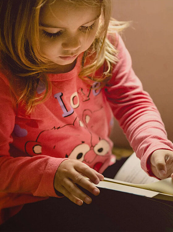 Young girl reading book for entertainment during travel