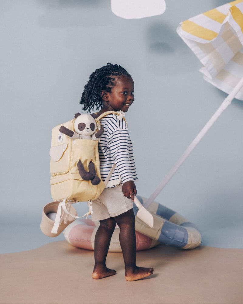 WeeWander yellow backpack worn by a young child smiling